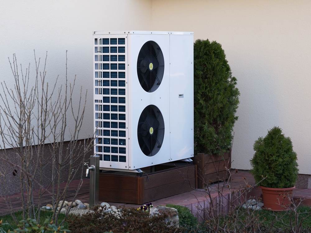 Modern ecological heat pump on garden is popular green energy source of heating, transfers thermal energy between indoor and outdoor, concept